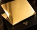 Gold MacBook Pro open on a black leather presentation box